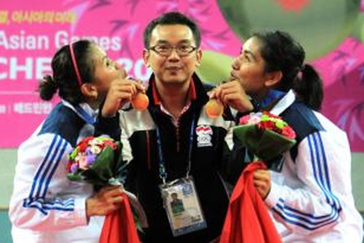 Pasangan ganda putri Indonesia, Greysia Polii (kiri)/Nitya Gresysia, berpose bersama pelatih Eng Hian (tengah) setelah merebut medali emas Asian Games 2014 dengan mengalahkan pasangan Jepang, Misaki Matsutomo/Ayaka Takahashi, pada final di Incheon, Korea Selatan, Sabtu (27/9/2014). Greysia/Nitya menang 21-15, 21-9. 