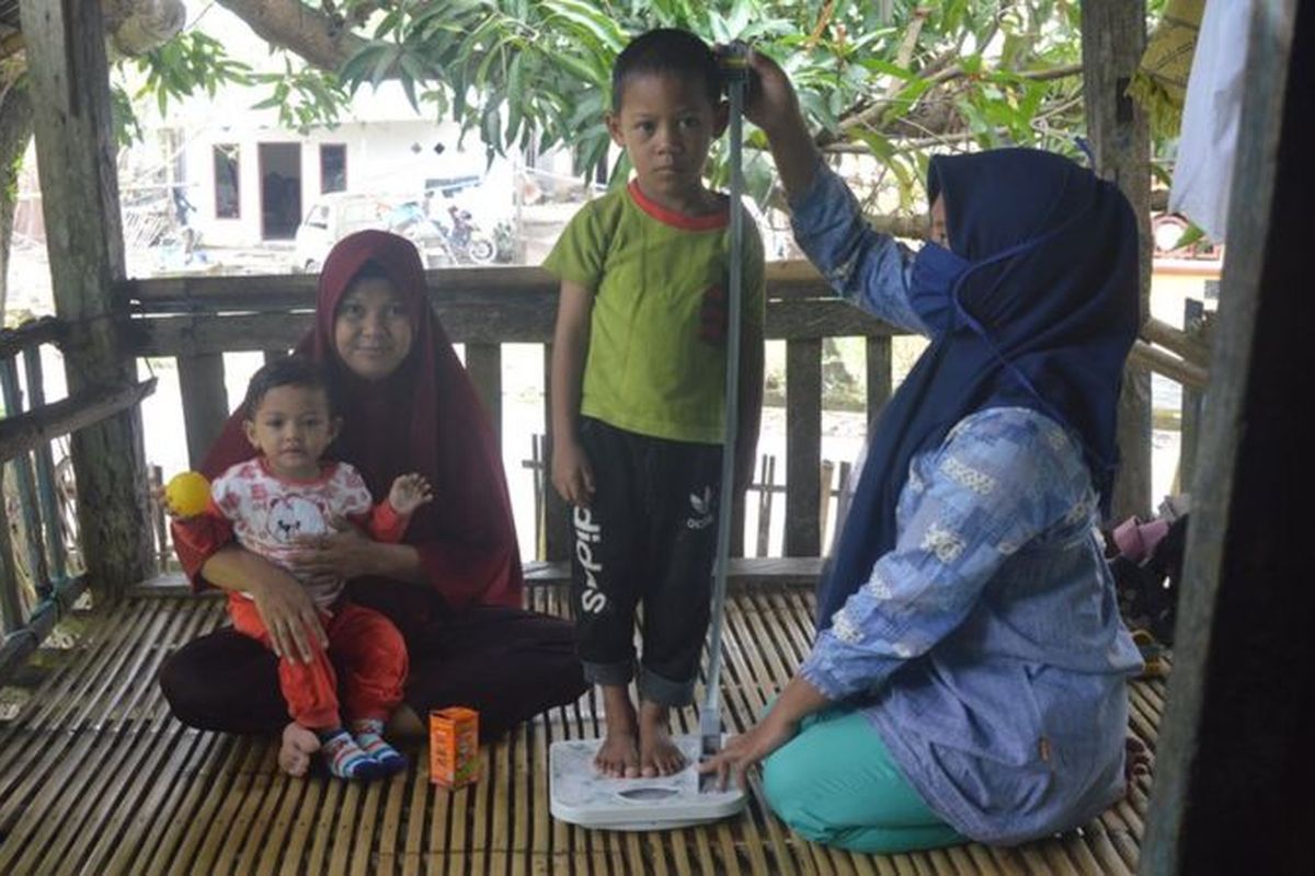 Kader Posyandu mendatangi rumah warga untuk mengukur tinggi badan dan penimbangan berat badan kepada dua balita penderita stunting di Kabupaten Takalar, Sulawesi Selatan. Kabupaten itu sukses menurunkan angka stunting dalam tiga tahun terakhir, namun kembali mencatat lonjakan di masa pandemi.