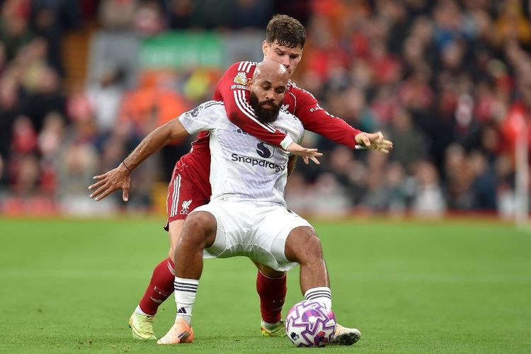 Bryan Mbeumo (depan) berduel dengan Milos Kerkez dalam pertandingan sepak bola Liga Inggris antara Liverpool vs Manchester United di Anfield di Liverpool, barat laut Inggris pada 19 Oktober 2025. (Foto oleh PETER POWELL / AFP)