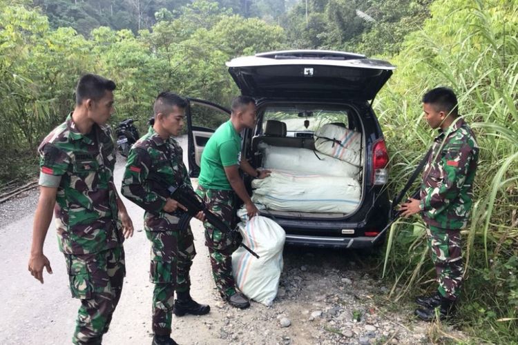 Personel TNI memperlihatkan mobil mengangkut 100 kilogram ganja di di Desa Pinding, Kecamatan Serbajadi, Kabupaten Aceh Timur, Rabu (4/4/2018).