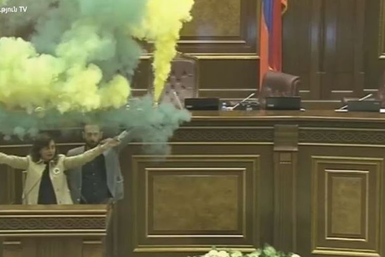 Ararat Mirzoian (kanan, belakang), dan Lena Nazarian ketika menyalakan flare saat sidang Parlemen Armenia Rabu (11/4/2018).