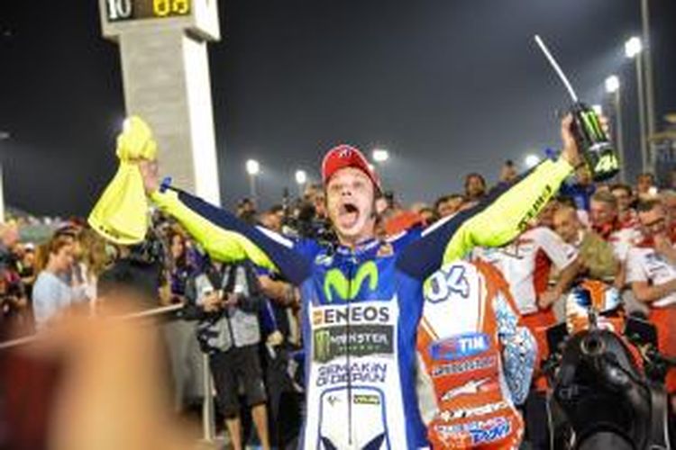 Pebalap Movistar Yamaha asal Italia, Valentino Rossi, merayakan kemenangan setelah finis pertama pada balapan GP Qatar di Sirkuit Losail, Minggu (29/3/2015).