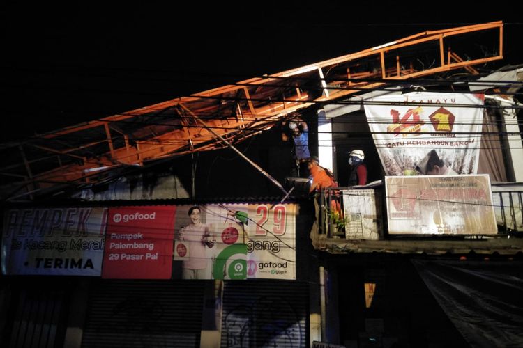 Petugas Damkar Depok tengah melakukan penanganan baliho roboh yang mengakibatkan menimpa lima ruko di Pasar Tugu, Cimanggis, Depok, Selasa (8/3/2022). 