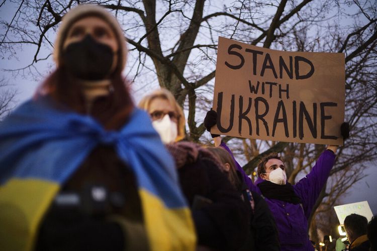Seorang pria memegang poster untuk mendukung Ukraina saat ia menghadiri demonstrasi di dekat kedutaan Rusia untuk memprotes eskalasi ketegangan antara Rusia dan Ukraina di Berlin, Jerman, Selasa, 22 Februari 2022.