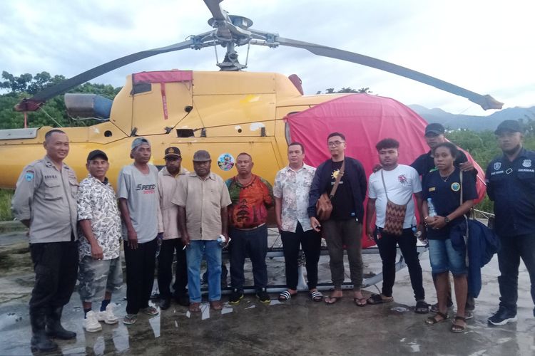 Perwakilan Dewan Adat Papua (DAP) Wilayah III Doberai dan CV. Salemo Raya bersama dengan pihak kepolisian saat berfoto bersama dibalik helikopter usia dilakukan gembok di SP III, Kabupaten Manokwari, Provinsi Papua Barat, Rabu (17/8/2022).