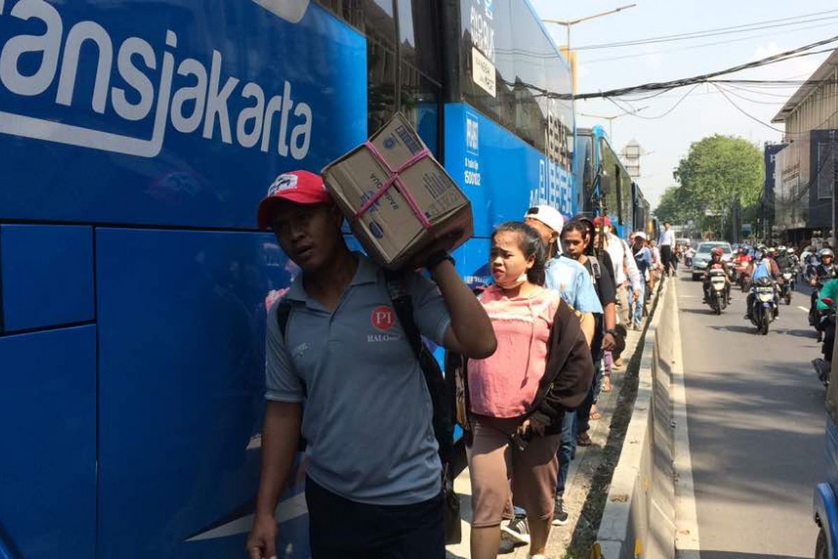 Petugas transjakarta mogok kerja dan menurunkan penumpang di Jalan KH Hasyim Ashari sebelum halte Harmoni, Jakarta Barat, Senin (12/6/2017). Aksi ini menimbulkan kekecewaan dari penumpang dan menyebabkan arus lalu lintas tersendat.