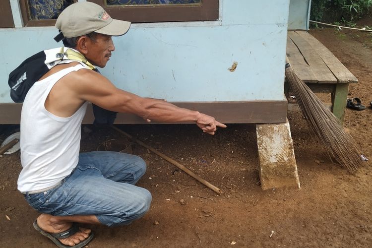 Seorang warga menunjukan pondasi rumah panggung yang bergeser di Purabaya, Sukabumi, Jawa Barat, Rabu (5/2/2020).