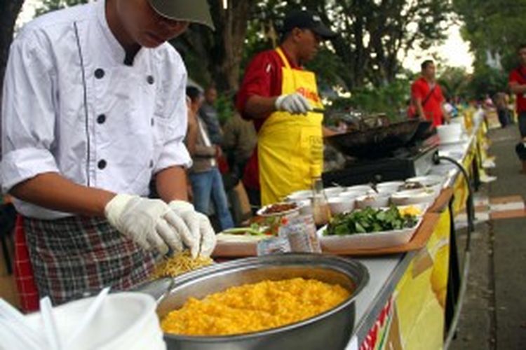 Para peserta memasak Bubur Manado secara massal dalam rangka HUT Manado ke-390 tahun, Sabtu (29/6/2013).