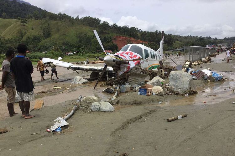 Sebuah pesawat rusak akibat terjangan banjir bandang di Sentani, Kabupaten Jayapura, Papua, Minggu (17/3/2019). Jumlah korban bencana banjir bandang yang terjadi pada Sabtu (16/3/2019) malam, hingga data yang masuk pada Minggu sore, terus bertambah menjadi 63 orang.