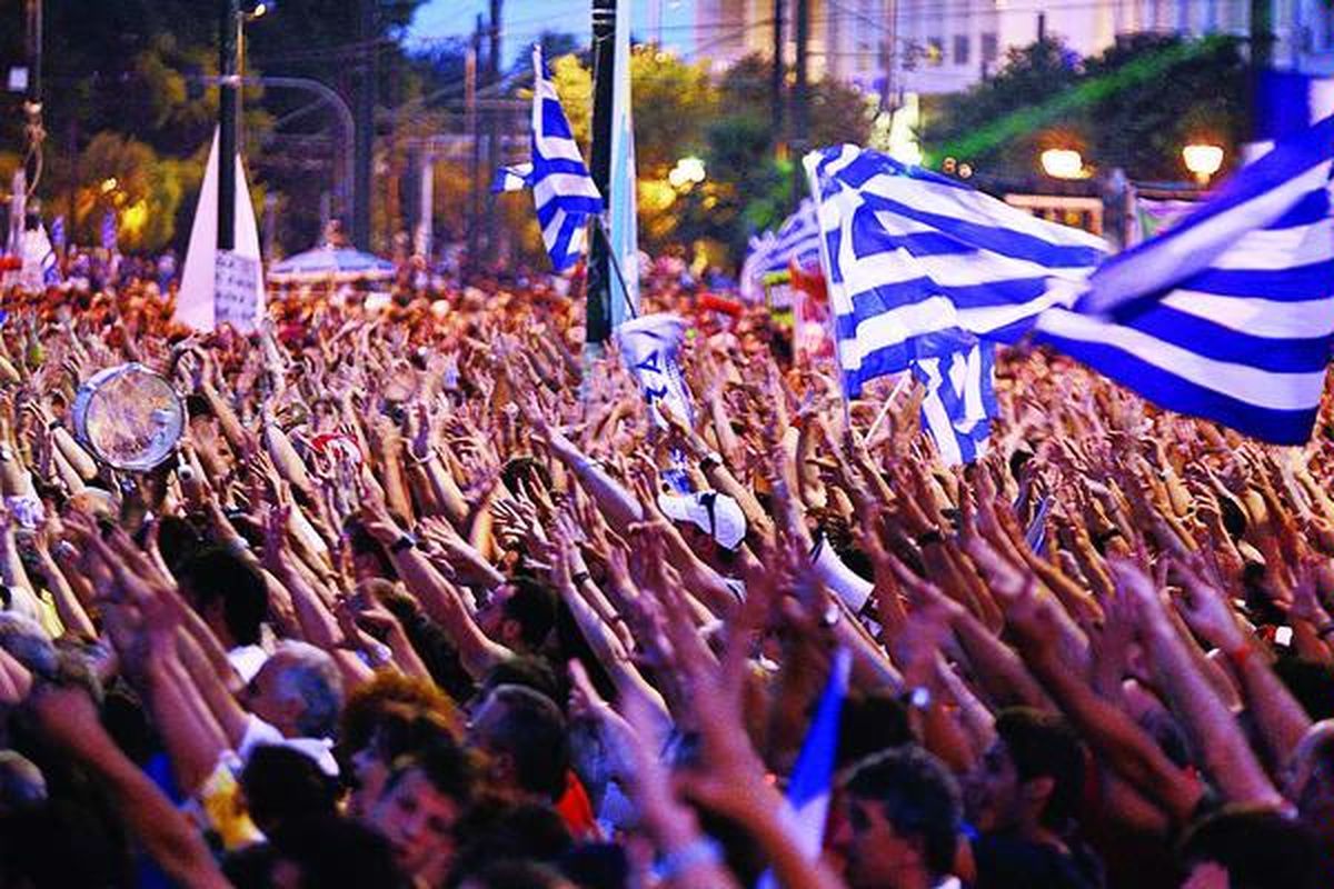 Para pengunjuk rasa di Yunani, beberapa di antaranya membawa bendera nasional, menuju lapangan Syntagma di depan Gedung Parlemen Yunani di pusat kota Athena dalam sebuah aksi damai untuk memprotes kebijakan baru pemerintah mereka, Selasa (21/6).