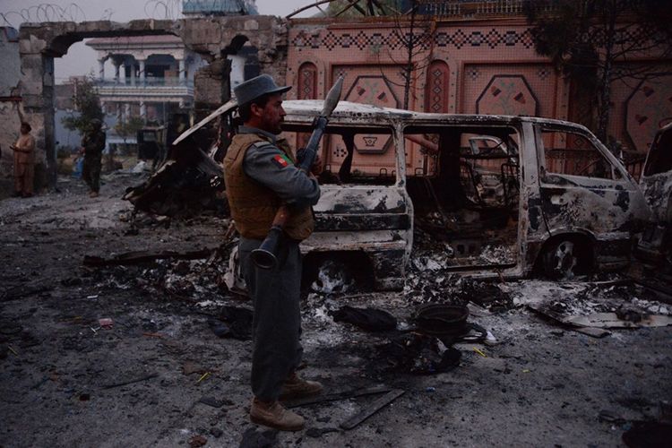 Pasukan keamanan Afghanistan mengamankan lokasi serangan terhadap kantor amal Save the Children di Jalalabad, Rabu (24/1/2018). (AFP/Noorullah Shirzada)