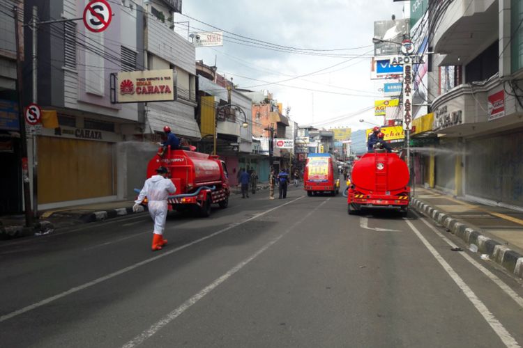 Dua mobil penyemprot Pemadam Kebakaran diturunkan untuk menyemprot pusat kota pasca ditutup, Minggu (26/04/2020)