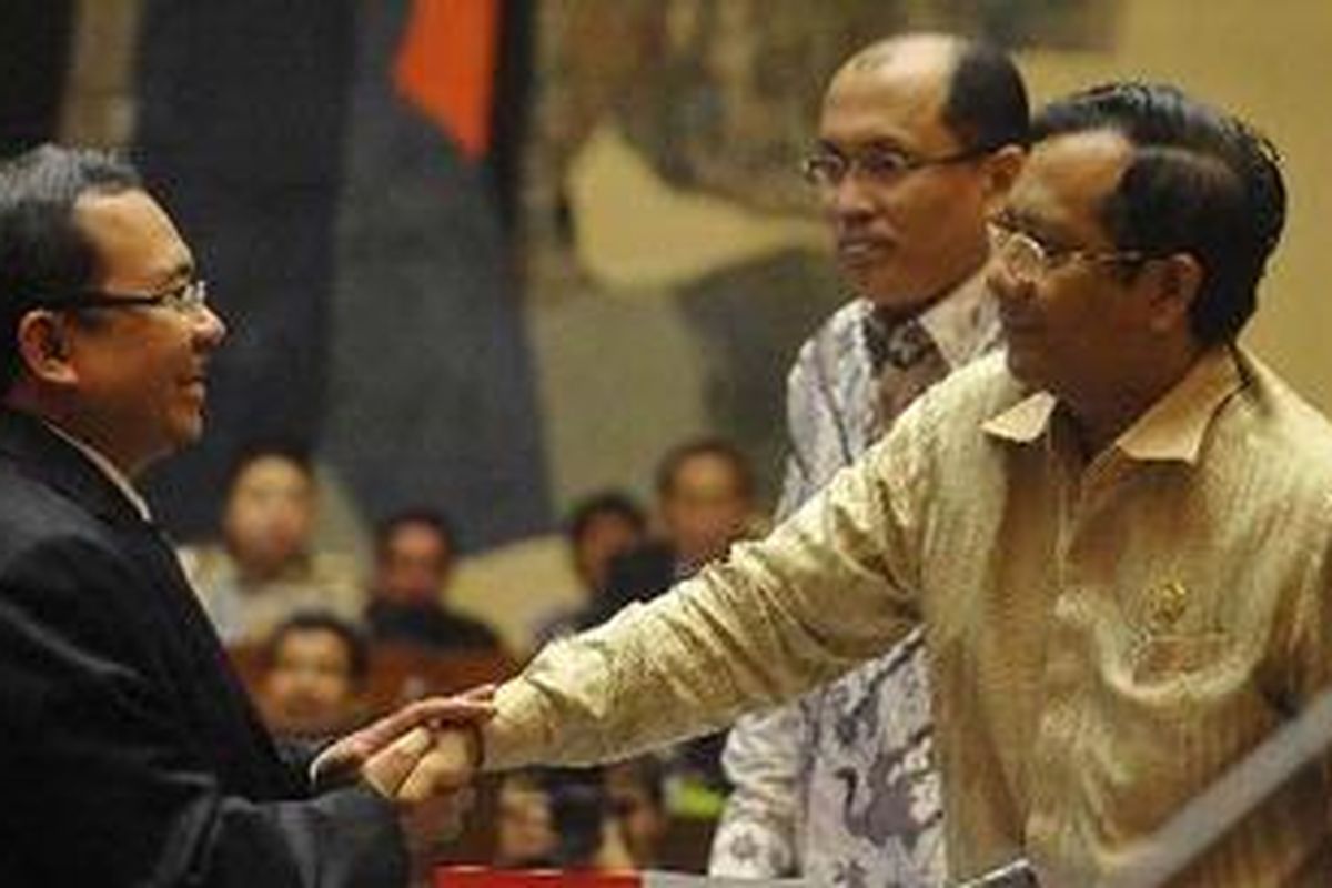 Ketua Mahkamah Konstitusi Mahfud MD (kanan) berjabat tangan dengan Wakil Ketua Dewan Perwakilan Rakyat Priyo Budi Santoso (kiri) disaksikan Sekretaris Jenderal MK Janedjri M Gaffar sebelum mengikuti rapat konsultasi dengan Panitia Kerja (Panja) Mafia Pemilu di Gedung MPR/DPR/DPD, Senayan, Jakarta, Selasa (21/6/2011). Panja dibentuk Komisi II DPR untuk mengungkap kasus pemalsuan surat MK yang diduga dilakukan oleh anggota Komisi Pemilihan Umum, Andi Nurpati.