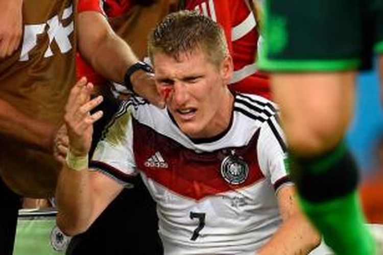 Pemain Jerman Bastian Schweinsteiger terluka setelah berbenturan dengan pemain Argentina Sergio Aguero dalam laga final Piala Dunia 2014 di Maracana Stadium, Rio de Janeiro, 13 Juli 2014. 