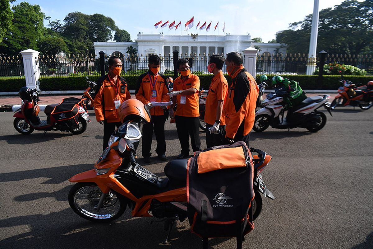 Sejumlah pegawai PT POS Indonesia (Persero) berkoordinasi sebelum pelepasan distribusi bantuan sosial sembako di depan Istana Merdeka, Jakarta, Senin (20/4/2020). Pemerintah mulai menyalurkan bantuan sosial untuk wilayah di DKI Jakarta dalam rangka penanganan COVID-19 di wilayah Jabodetabek.