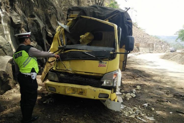 Polisi dari satuan lalu lintas Polres Trenggalek menunjukkan truk yang rusak akibat tertimpa longsor di Kilometer 16, Kecamatan Tugu, Kabupaten Trenggalek, Jawa Timur, Jumat (9/11/2018).