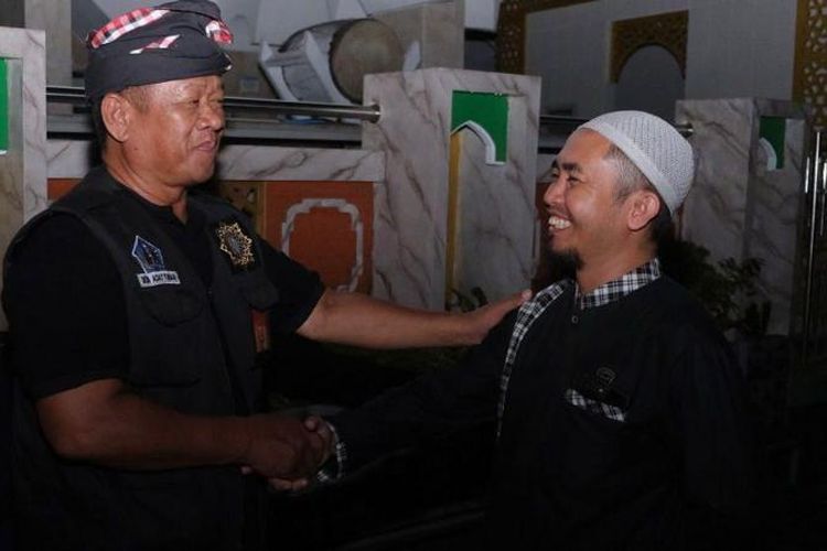 Pecalang atau petugas pengamanan adat Bali bersalaman dengan umat Islam usai melaksanakan salat tarawih pertama bulan Ramadan 1445 Hijriah yang bertepatan dengan Hari Raya Nyepi Tahun Baru Saka 1946 di Masjid Agung Asasuttaqwa, Desa Adat Tuban, Badung, Bali, Senin (11/03/2024)
