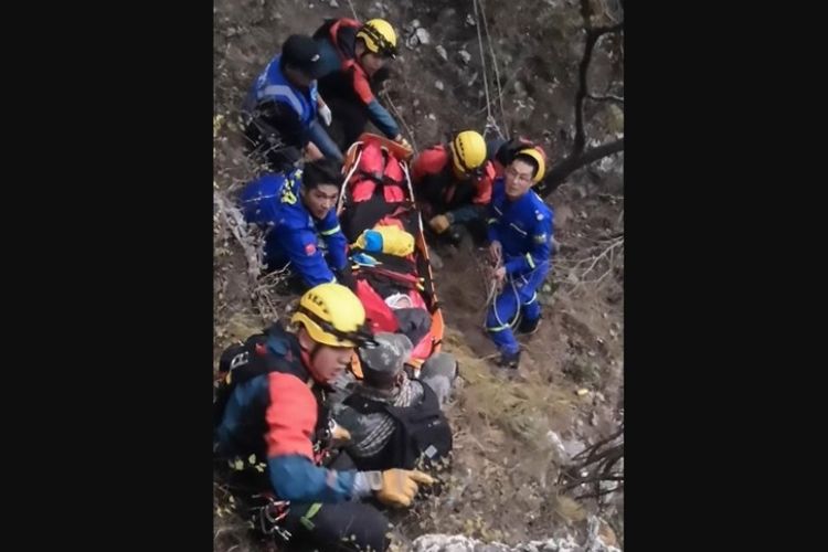 Tim penyelamat berupaya mengevakuasi perempuan turis yang terjadi ke tebing di Tembok Besar China menggunakan tandu.