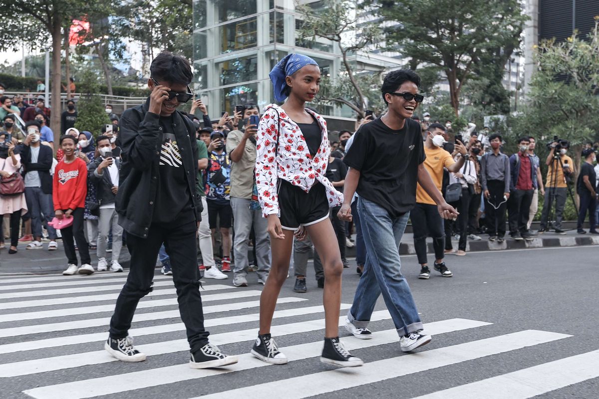 Roy (Citayam), Mami (Tanah Abang), dan Oman (Tanah Abang) memanfaatkan zebra cross untuk ajang unjuk pakaian di kawasan Dukuh Atas, Jakarta, Rabu (20/7/2022).  Fenomena Citayam Fashion Week di kawasan Dukuh Atas mendadak viral karena gaya busana nyentik yang didominasi anak muda dari Depok, Citayam, dan Bojonggede.