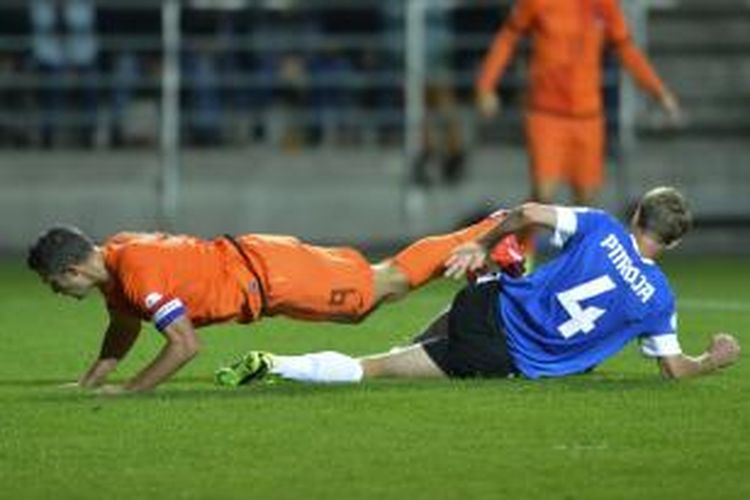 Bek Estonia Raio Piiroja melanggar penyerang Belanda Robin van Persie di kotak penalti, pada pertandingan kualifikasi Piala Dunia 2014, di Tallinn, 6 September 2013. 