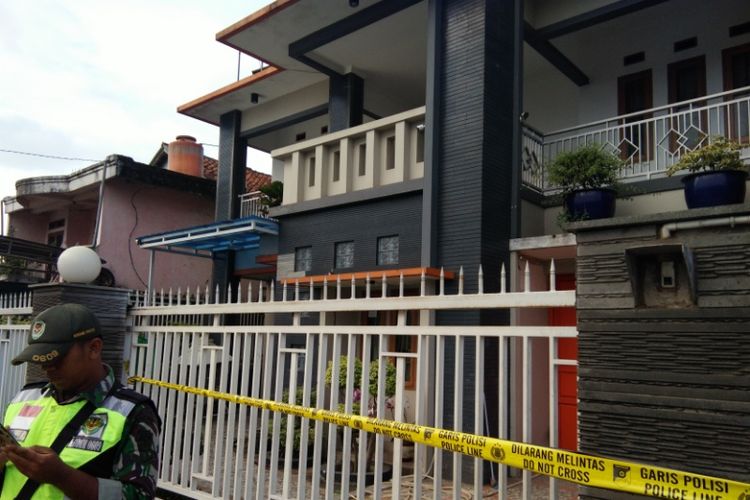 Petugas keamanan saat berjaga di depan rumah JS, tersangka pembuat miras oplosan di Cicalengka, Kabupaten Bandung, Rabu (11/4/2018).
