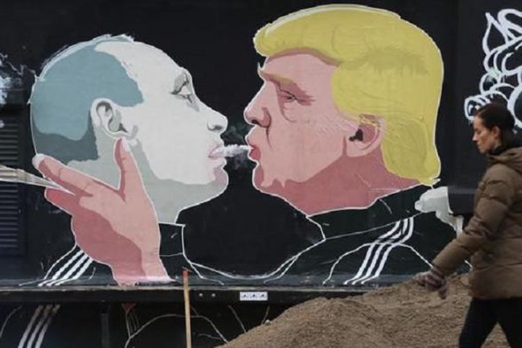 Seorang wanita melintas di depan mural Valdimir Putin dan Donald Trump yang ada di tembok bar di kota tua Vilnius, Lithuania, 14 Mei 2016. Gambar itu merupakan sebentuk interprestasi seorang seniman tentang hubungan antara AS dan Rusia.