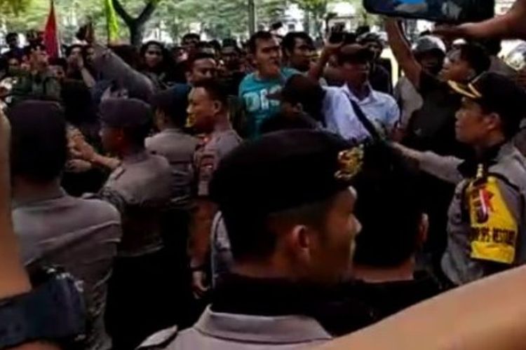 Polisi sedang menenangkan massa yang menggelar aksi pro dan kontra terhadap kinerja Presiden Joko Widodo di DPRD Sumut, Kamis (20/9/2018). 