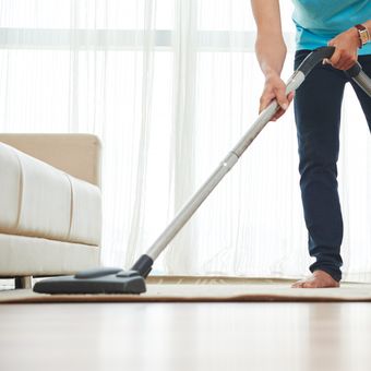 Ilustrasi menggunakan vacuum cleaner untuk membersihkan lantai. 