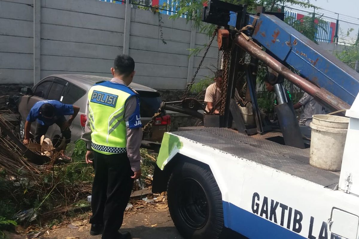Satu unit mobil minibus masuk kedalam parit di kawasan Kalideres Jakarta Barat, Selasa (5/11/2019)
