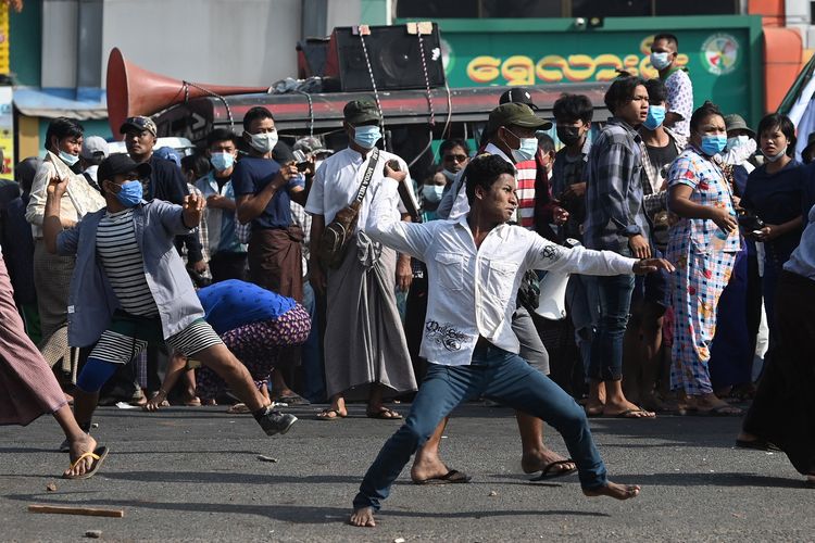 Pendukung militer Myanmar melempar proyektil ke pedemo anti-kudeta di Yangon, Myanmar, pada Kamis (25/2/2021), dalam demo menentang kudeta.