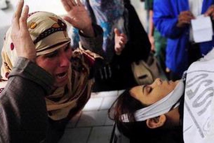 Seorang ibu menangisi putrinya -seorang sukarelawan pemberantasan polio- yang tewas ditembak di Karachi, Senin (17/12/2012).