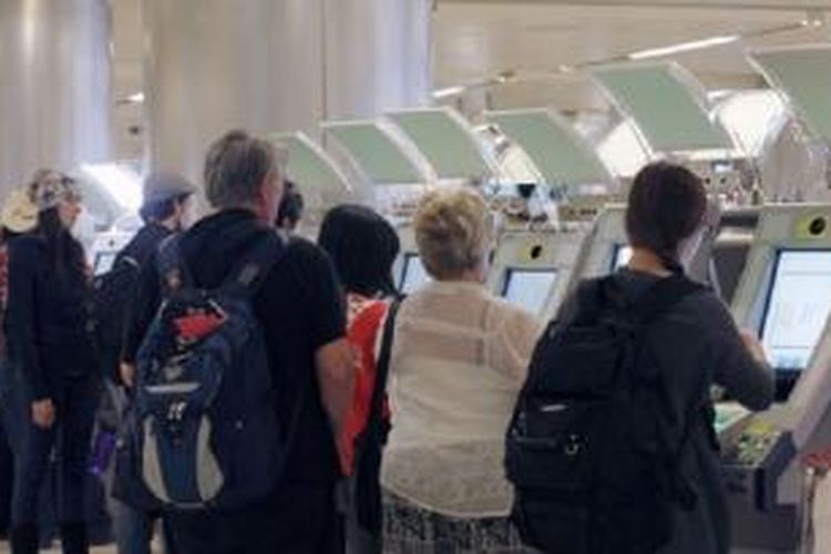 Para penumpang tiba dari luar negeri di Bandara Internasional Los Angeles menggunakan kios baru untuk memeriksa paspor secara otomatis.