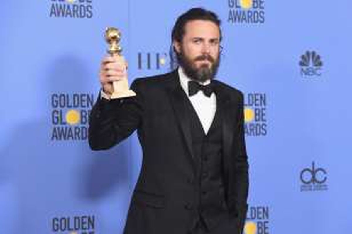 Aktor Casey Affleck menunjukkan trofi aktor terbaik dalam Golden Globe Awards 2017 yang digelar di The Beverly Hilton Hotel, Beverly Hills, California, Minggu (8/1/2017).