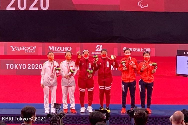 Leani Ratri Oktila/Khalimatus Sadiyah berdiri di podium usai meraih medali emas Paralimpiade Tokyo 2020.
