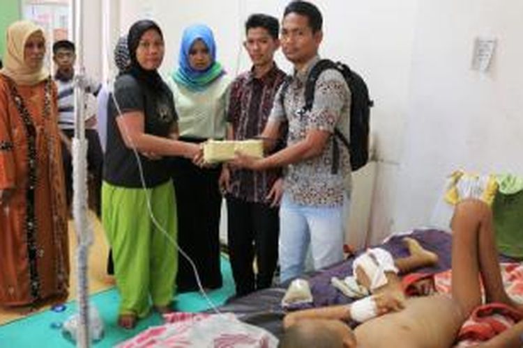 Perwakilan mahasiswa menyerahkan bantuan hasil penggalangan, kepada orangtua Kholid, penderita tumor di kaki, Selasa (31/3/2015).