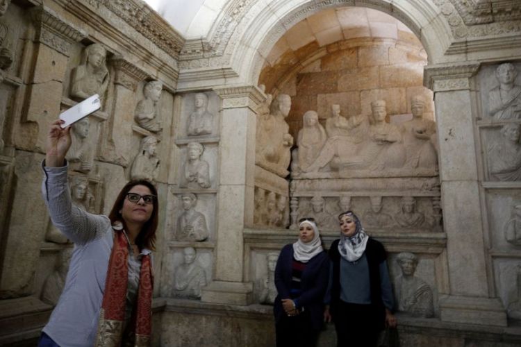 Para pengunjung berfoto di salah satu seksi Museum Nasional Suriah. Museum tersebut kembali dibuka setelah ditutup pada 2012 akibat perang sipil yang berkecamuk.