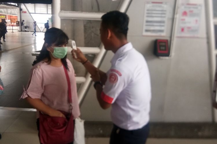 Petugas stasiun sedang melakukan pemeriksaan suhu tubuh terhadap seorang penumpang KRL di Stasiun Bogor, Kamis (12/3/2020). Pemeriksaan tersebut dilakukan sebagai bentuk antisipasi penyebaran virus corona di kawasan stasiun.