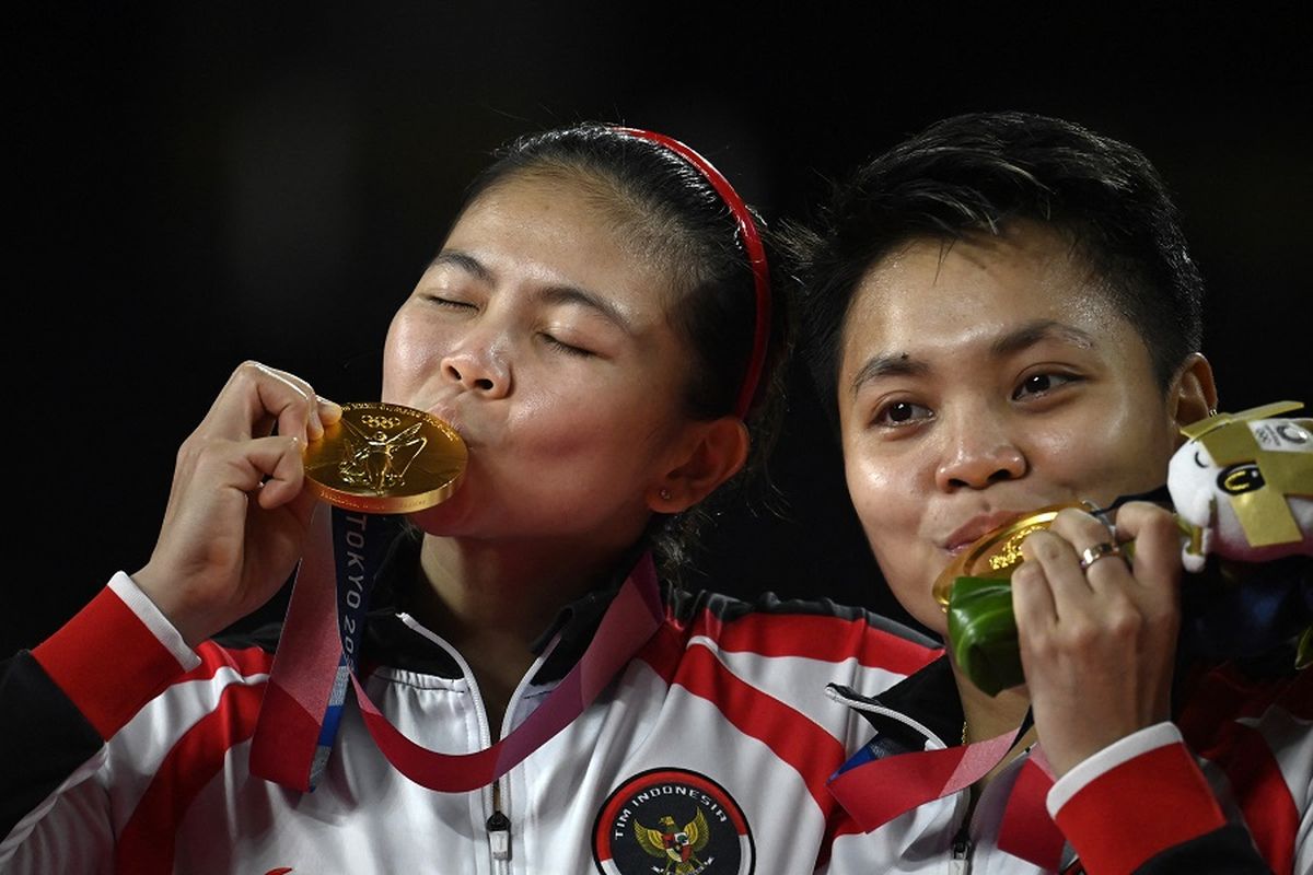 Pasangan ganda putri Indonesia Greysia Polii dan Apriyani Rahayu (kanan) berpose dengan medali emas bulu tangkis ganda putri pada upacara Olimpiade Tokyo 2020 di Musashino Forest Sports Plaza di Tokyo pada 2 Agustus 2021.