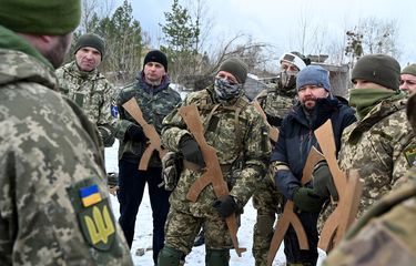 Tentara cadangan Ukraina memegang replika kayu senapan Kalashnikov, dalam latihan militer di dekat Kiev pada Sabtu (25/12/2021). Para peserta pelatihan adalah bagian dari batalyon cadangan yang dibentuk untuk melindungi sebuah distrik di Kiev jika terjadi serangan terhadap kota terbesar di Ukraina itu. Puluhan warga sipil bergabung dengan tentara cadangan Ukraina dalam beberapa bulan terakhir, karena kekhawatiran meningkat bahwa Rusia, yang menurut Kiev telah mengumpulkan sekitar 100.000 tentara di sisi perbatasannya, sedang merencanakan serangan skala besar.