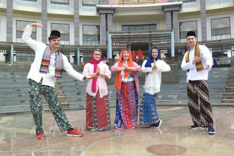 Atlet dan pelatih Asian Games asal Uzbekistan berfoto memakai baju adat Betawi saat berkunjung ke PBB Setu Babakan, Jakarta Selatan, Minggu (26/8/2018).