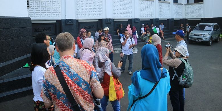 Anggota Komunitas Jelajah Budaya tengah mendengarkan pengarahan Ngabuburit Kota Tua di halaman Museum Bank Mandiri, Jakarta, Sabtu (9/7/2017).
