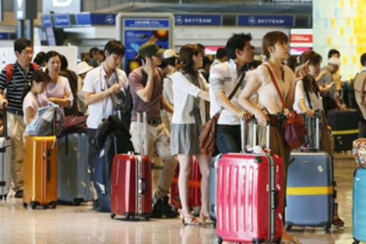 Antrean turis China di sebuah bandara.