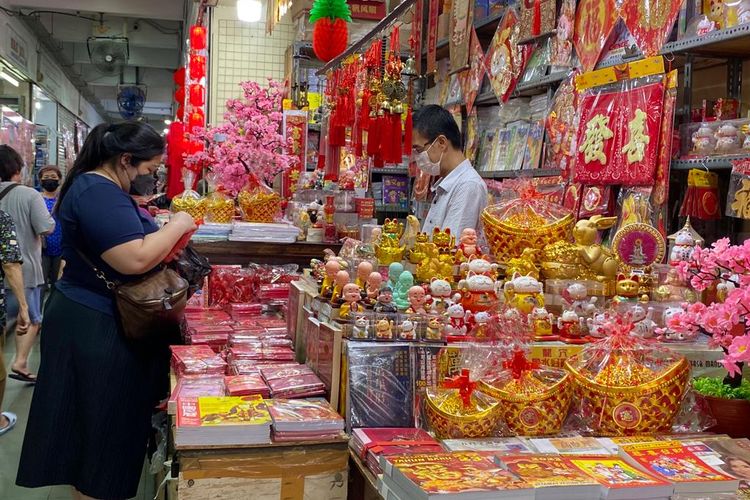 Pedagang pernak-pernik khas Imlek di Pecinan, Glodok, Jakarta Barat ramai dikunjungi pembeli, Rabu (18/1/2023). Warga berburu berbagai kebutuhan Imlek termasuk amplop, lampion, patung, sampai tanaman hias palsu. 