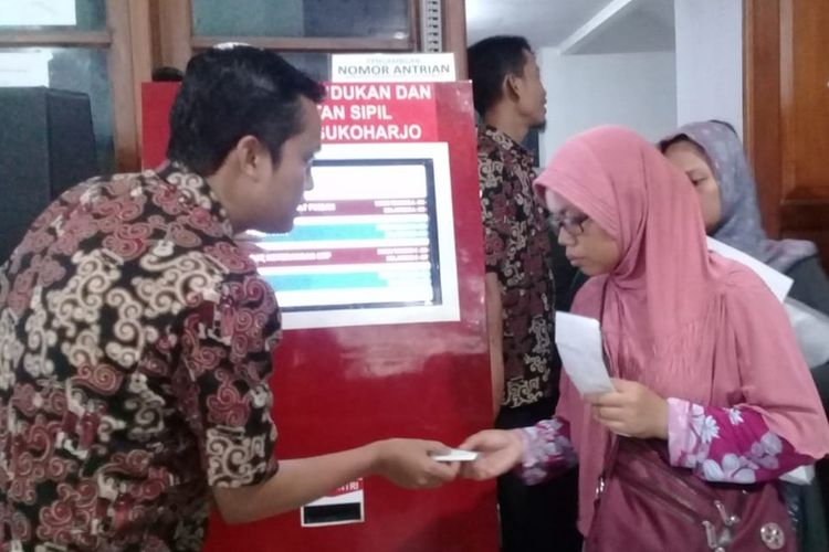 Warga mengambil nomor antrean untuk perekaman e-KTP di Disdukcapil Sukoharjo, Jawa Tengah, Rabu (4/12/2019).