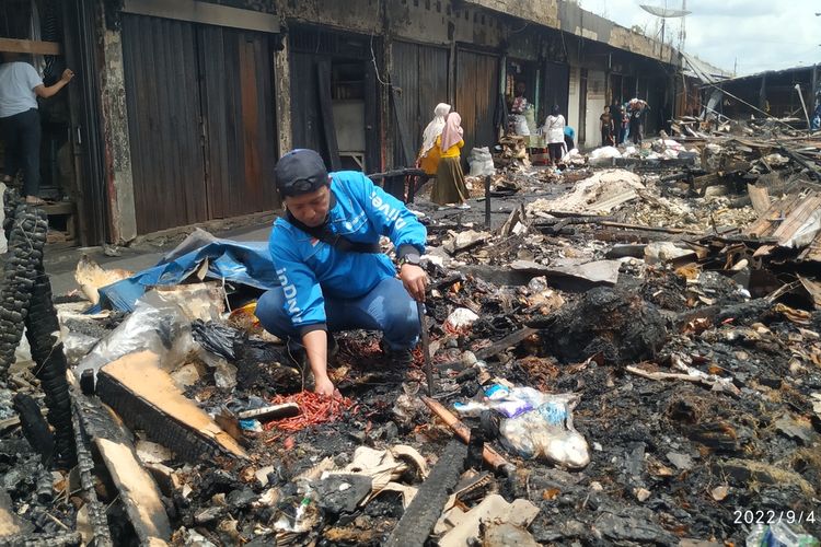 Seorang pedagang mengais puing-puing lapak dagangannya yang terbakar di Pasar Lettu Bakri, Kecamatan Warudoyong, Sukabumi, Jawa Barat, Minggu (4/9/2022).