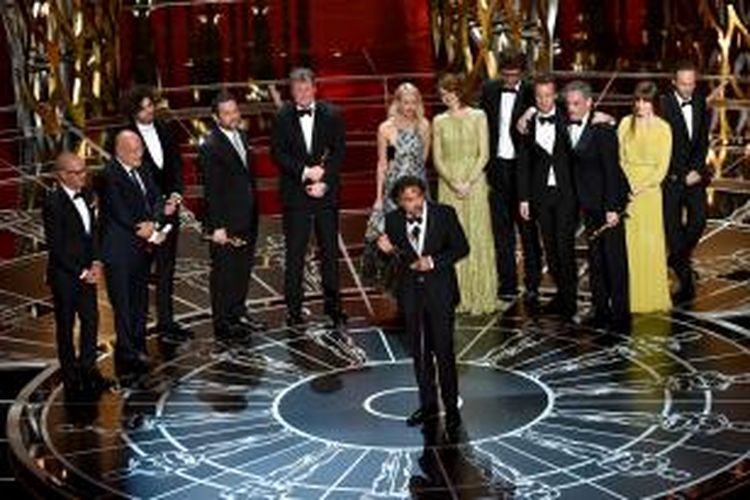 Sutradara Alejandro Gonzalez Inarritu (tengah) dikelilingi artis peran dan kru film Birdman ketika menerima penghargaan Best Picture dalam Academy Awards atau Piala Oscar ke-87 di Dolby Theatre, Hollywood, California, Minggu (22/2/2015).