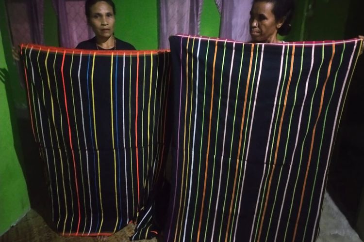 Dari kiri ke kanan, Petronela Evi (46) dan Regina Inus (56) sedang memegang kain tenun puncatiti hasil karya tangan mereka di kampung Wangkar, Desa Ranamese, Kecamatan Congkar, Kabupaten Manggarai Timur, Nusa Tenggara Timur, Sabtu, (11/3/2023).