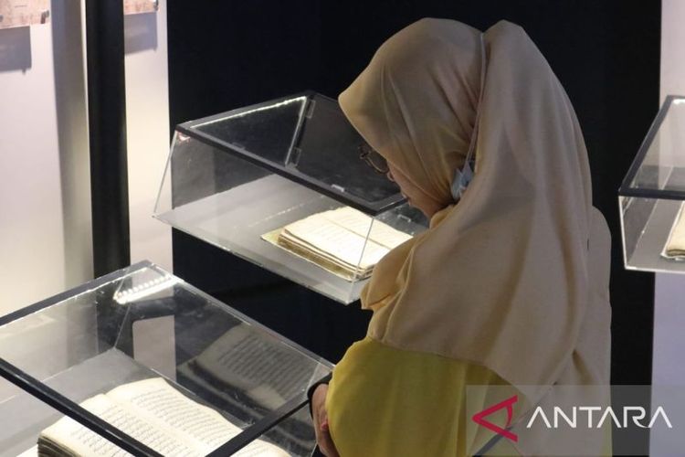 Salah seorang pengunjung sedang melihat naskah tempo dulu yang dipamerkan di Gedung Paran Temporer, Museum Aceh, di Banda Aceh, Kamis (10/8/2023)