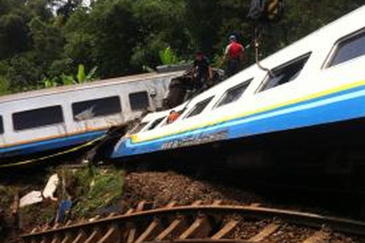 Petugas berusaha mengevakuasi gerbong Kereta Api (KA) Malabar jurusan Bandung-Malang yang terguling akibat tanah longsor di Kampung Terung, Desa Mekarsari, Kecamatan Ciawi, Kabupaten Tasikmalaya, Jawa Barat, Sabtu (5/4/2014).