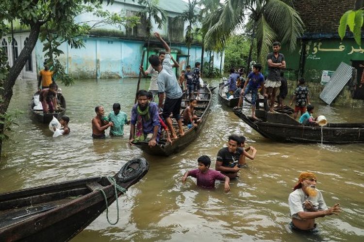 Orang-orang berkumpul untuk mengumpulkan bantuan makanan di daerah pemukiman yang terendam banjir menyusul hujan deras monsun di Companiganj pada 20 Juni 2022. Sedikitnya 26 orang lagi tewas dalam banjir monsun dan sambaran petir di India, sementara jutaan orang masih terdampar di negara itu dan negara tetangga Bangladesh, kata pihak berwenang pada 20 Juni.